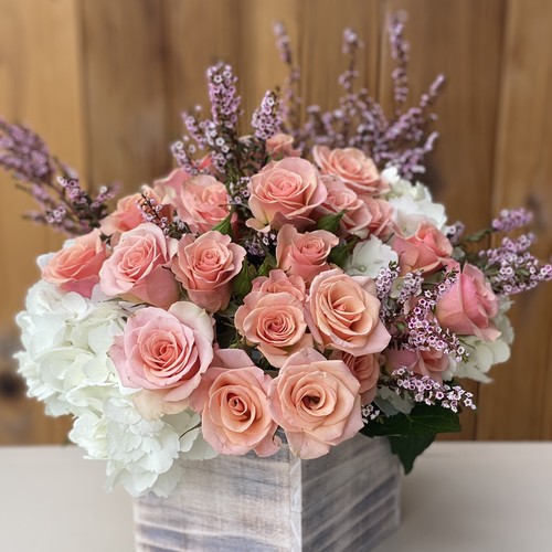 Peach roses with white hydrangeas and lavender waxflower in wood box by Raleigh floral design